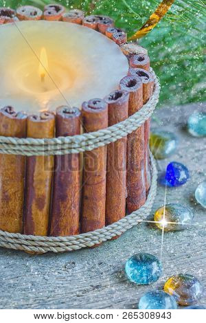 Candlestick Of Cinnamon Sticks With Christmas Decoration And Branch Of Fir Background With Bokeh.