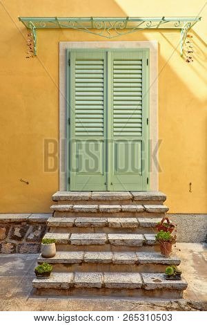 Lovran, Istria, Croatia. Picturesque embankment along resort old town at coast of Adriatic Sea with blue water and waves. Trees with green leaves. Warm sunny summer landscape.