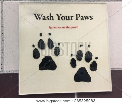 A Amusing Sign Outside A Public Convenience Telling People To Wash Their Paws