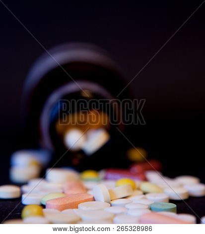 A Bottle Of Spilled Pills On Black Background.levitating Tablets. Tablets On A Dark Background That 