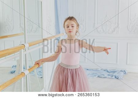 Young Classical Ballet Dancer Girl In Dance Class. Beautiful Graceful Ballerina Practice Ballet Posi