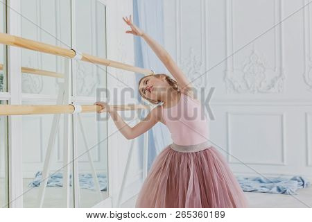 Young Classical Ballet Dancer Girl In Dance Class. Beautiful Graceful Ballerina Practice Ballet Posi