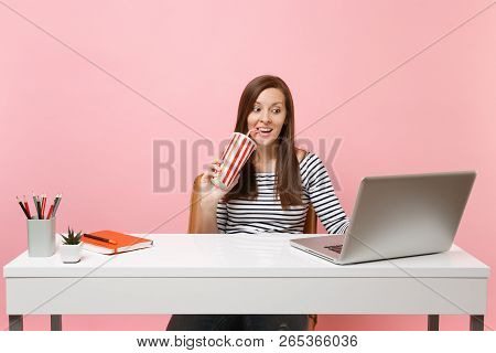 Excited Woman Drinking From Plactic Cup With Cola Soda Sit Working On Project At Office At White Des