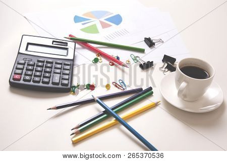 Calculator With Colorful Pencils And Coffee On Desk