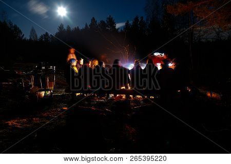 People Sit At Night Round Bright Bonfire