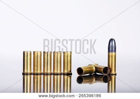 Group Of Ammunition On A Table With Reflections, White Background