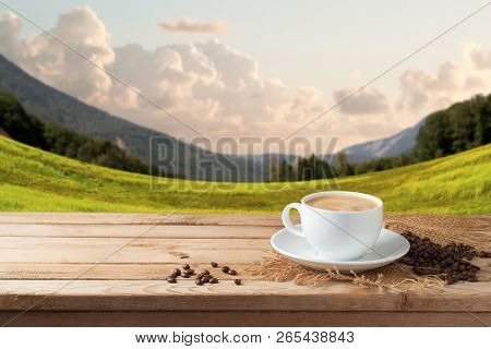 Coffee Cup On Wooden Table Over Beautiful Landscape Background With Copy Space