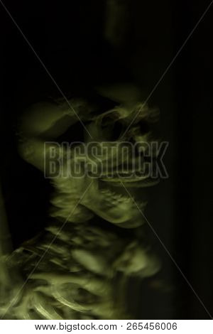 Skeleton Hanging In The Darkness Ready To Scare People. Intentional Motion Blur To Convey Movement A