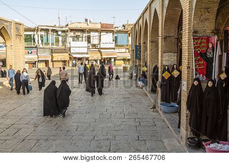 Isfahan, Iran - August 20, 2016: Women Wearing Islamic Modest Clothing Passing By The Shops Of Islam