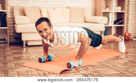Push Ups On Floor With Dumbbells. Father Spotting. Sport At Home. Warm Up In Quarter. Lying On Gym M