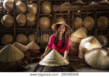Asian Traveler Female Craftsman Making The Traditional Vietnam Hat In The Old Traditional House In A