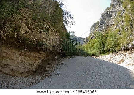 seinor male hiker relaxing in nature while  walking tour on beautiful summer day on canyon of  dried riverbed