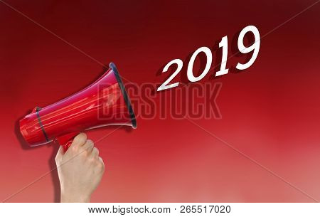 Hand Holding A Red Loudspealer Annoucing New Year 2019 On Red Background