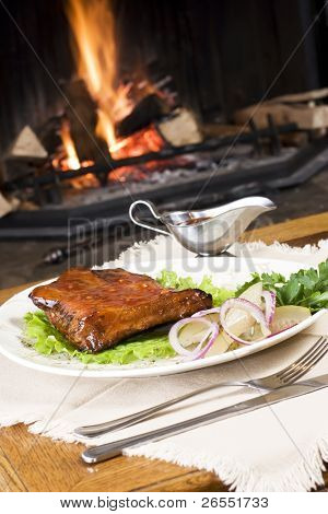 essen Fleisch mit Gemüse und Pfändungen auf einem weißen Teller, sitzt auf einem Tisch vor einem bur
