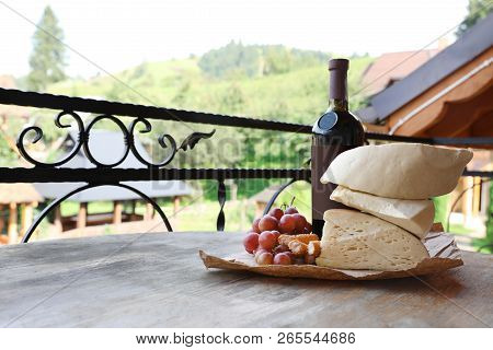 Bunch Of Grapes, Wine, Cheese And Peaches On Wooden Table. Space For Text
