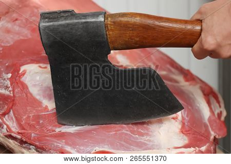 Butcher Chopping Fresh Raw Meat With Axe In Shop, Closeup