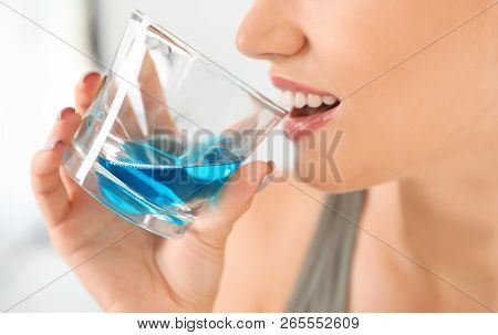Woman Rinsing Mouth With Mouthwash In Bathroom, Closeup.teeth Care
