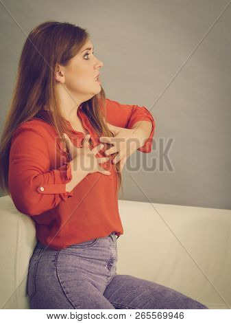Angry, Pissed Off Young Woman. Attractive Female With Long Brown Hair Sitting On Sofa Being Mad And 