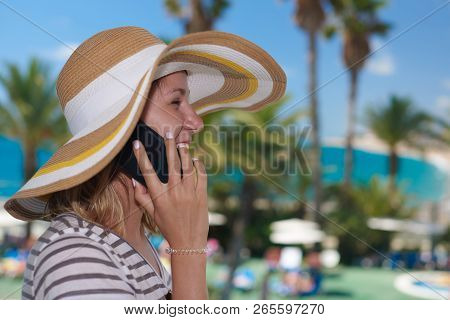 Young Girl In Bonnet Hat Calling By Phone Against Wonderful Sea View. Santa Susanna. Cataluna. Spain