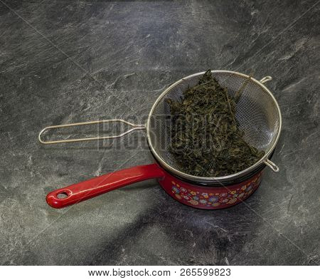 Cooking Of Marijuana Green Butter In Hot Water In Kitchen