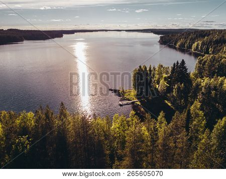 Small Pier At The Shore Of A Big Lake On A Evening With Sun Reflecting In The Water, Finland Suomuss