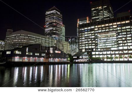Canary Wharf skyskrabere i London om natten, med refleksioner i floden