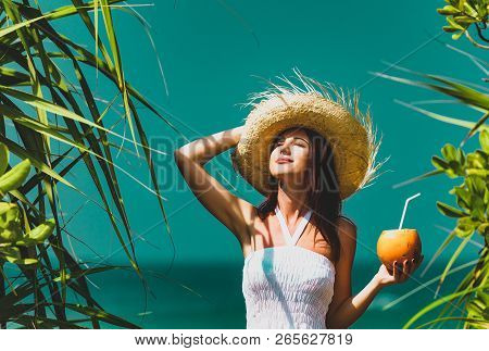 Young Woman In A Hat With Coconut Cocktail Near The Sea