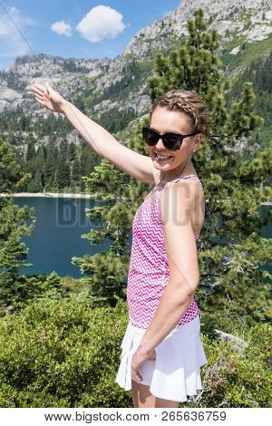 Young Woman Points Her Arms To Lead The Way On Fanettte Island In Lake Tahoe California. Concept For