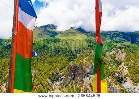 Traditional Buddhist Prayer Flags Over Foggy Mountain Background In Manang Village, Nepal