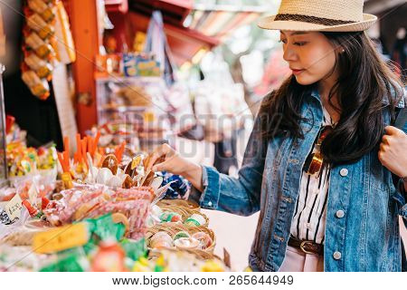 Elegant Lady Choosing Sweets At The Candy Vendor In The Traditional Market. Traveler Looking At The 