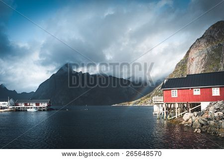 Rainbow Ofer Red Houses Rorbuer Of Reine In Lofoten, Norway With Red Rorbu Houses, Clouds, Rainy Blu