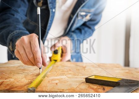 Carpenter Working Carefully Looking At The Plans Work In Carpentry. He Is Successful Entrepreneur At