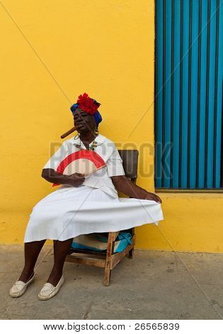 HAVANA-NOVEMBER 30:Old lady with a fine cigar dressed in typical cuban clothes November 30, 2010 in Havana.