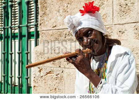 HAVANA-DECEMBER 24: rynket gammel dame med en kæmpe cigar iført typisk tøj og afrocuban religio
