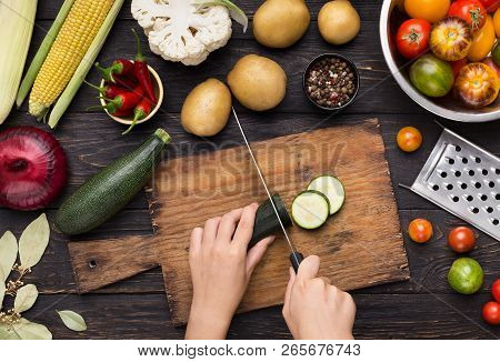 Preparing Balanced Food. Woman Cutting Green Zucchini Into Slices On Wooden Board In Kitchen, Top Vi