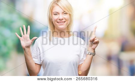 Young beautiful blonde woman wearing white t-shirt over isolated background showing and pointing up with fingers number six while smiling confident and happy.