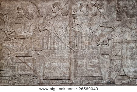 Muinaisen assyrian clay relief kuvaa rivi sotureita aseita ja cuneiform kirjoitetun tekstin 