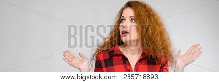 A Girl In A Plaid Shirt Spreads Her Arms Out To The Sides. Young Girl With Red Hair