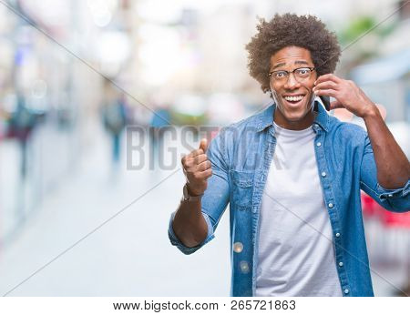 Afro american man talking on the phone over isolated background very happy and excited, winner expression celebrating victory screaming with big smile and raised hands