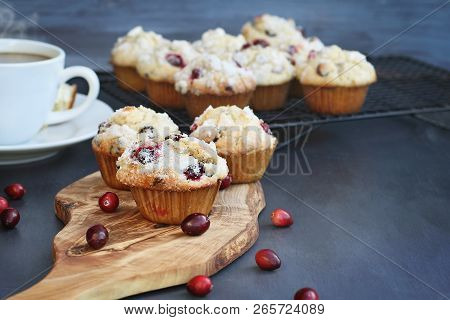 Cranberry Muffins On A Wood Cutting Board With More Cooling On A Bakers Rack. Extreme Shallow Depth 