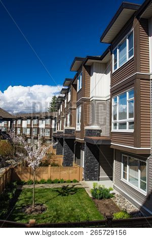 New Modern Low Rise Appartament Complex On A Sunny Spring Day With Blooming Sakura Trees.