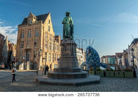Bruges, Belgium - October 6, 2018: The Statue Of Jan Van Eyck And In The Background, Skyscraper By S