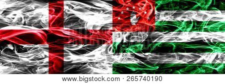 England Vs Abkhazia, Abkhazian Smoke Flags Placed Side By Side. Thick Colored Silky Smoke Flags Of E