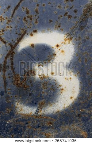 White Number Seven Painted On Rusty Blue Metal