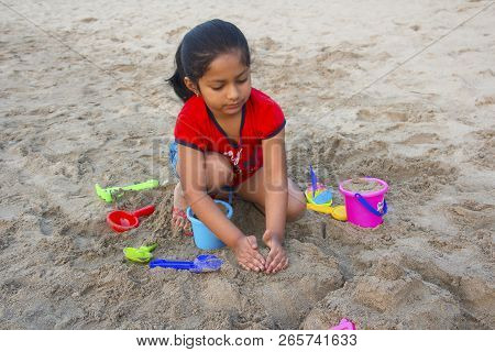 Little Girl Trying To Make A Fort With Sand On Alibag Beach, India