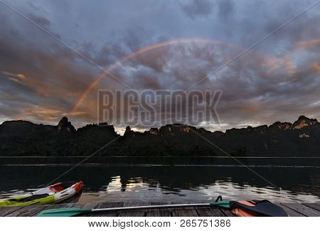 Mountain Nature And Lake Background With Bright Rainbow In Dramatic Cloudy Sky