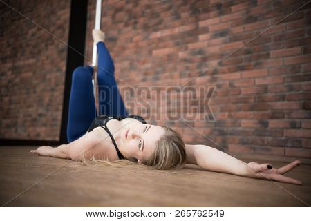 Girl Lie On The Floor Near A Pylon Posing In A Pole Dance Studio