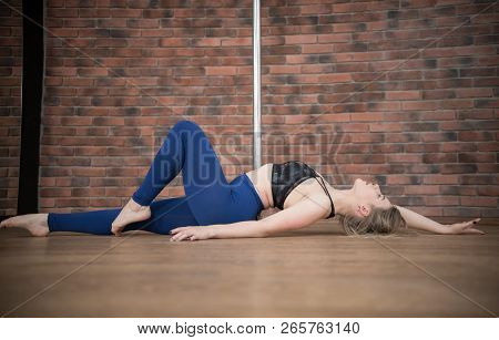 Girl Near A Pylon Posing In A Pole Dance Studio