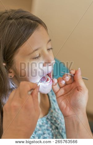 Little Girl At The Reception In The Dentists Office. Little Girl Sitting In A Chair Near A Dentist A