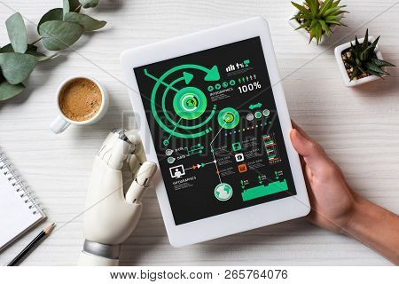Cropped Image Of Businessman With Prosthesis Arm Using Digital Tablet With Infrographic At Table Wit